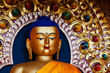 Gilded statue of Sakyamuni Buddha in Buddhist Tsuglagkhang temple gompa. McLeod Ganj, Himachal Pradesh, India