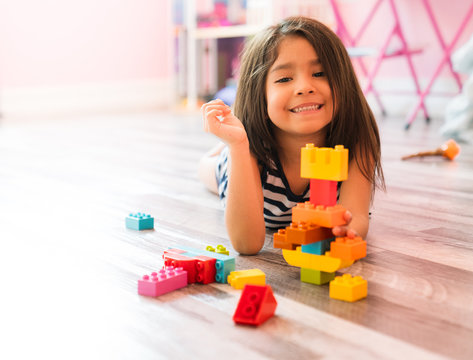 Little Girl Playing With Construction Blocks at Home
