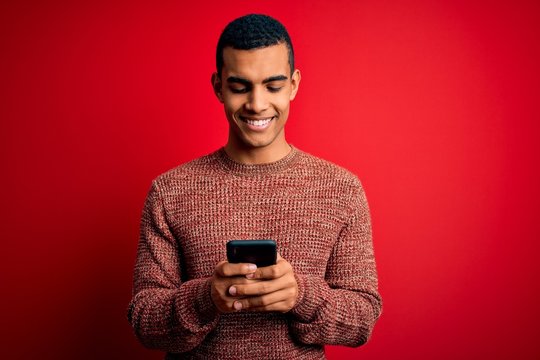 Handsome african american man having conversation using smartphone over red background with a happy face standing and smiling with a confident smile showing teeth - Powered by Adobe