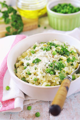 Italian cuisine. Plate of green pea risotto with green pea, parmesan cheese, olive oil and parsley