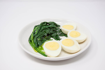 A plate of spinach with boiled eggs