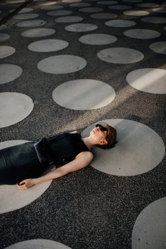 Elegant woman lying on ground with gray spots