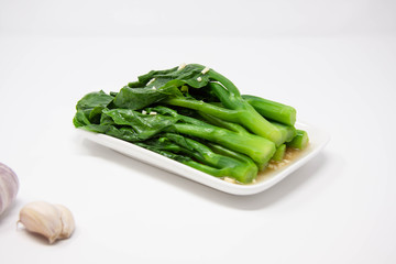 a plate of green gai lan (Chinese brocolli) with minced garlic