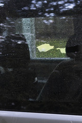 shattered glass of a car window being romoved with a black glove