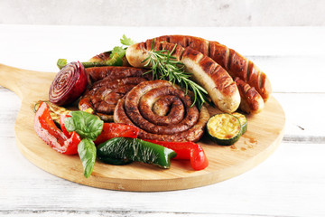 Assorted delicious grilled meat with vegetable on a barbecue with grilled sausages and vegetables on table
