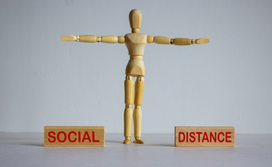 COVID-19 Pandemic Coronavirus concept. Wooden blocks with words social distance. Wooden model of human.
