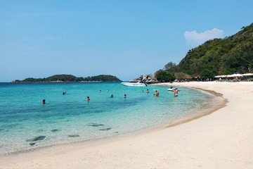 Fototapeta na wymiar Tropical beach, white sand, turquoise sea, people swimming and relaxing. Pattaya Thailand March 2020 