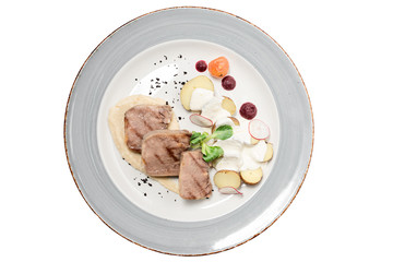 beef tongue on a plate on a white background