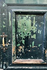 Old and damaged wooden door with forged details in Spain