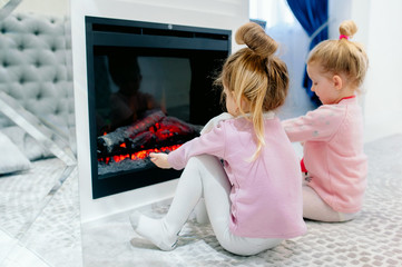 Family concept, home interior - these are sisters playing together. Happy kids: sisters by the...