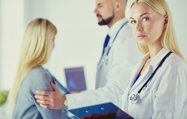 Handsome male doctor consulting a couple about infertility in his medical office