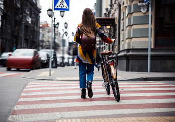 Cycler walking with her bike on the pedestrian crosswalk