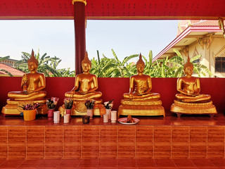 Row of golden buddha statues in an asian buddhist temple