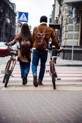 Young couple with bicycles on the pedestrian crosswalk