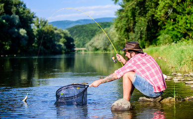 Making me happy. mature bearded man with fish on rod. successful fisherman in lake water. hipster fishing with spoon-bait. fly fish hobby of man hipster. big game fishing. relax on nature