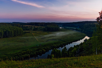 river and forest from a high hill at sunset