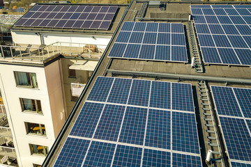 Aerial view of solar photovoltaic panels on a roof top of residential building block for producing...