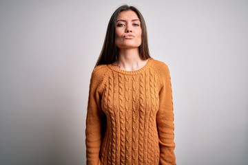 Young beautiful woman with blue eyes wearing casual sweater standing over white background looking at the camera blowing a kiss on air being lovely and sexy. Love expression.