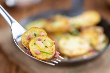 Portion of Fried Potatoes on an old wooden table (selective focus; close-up)