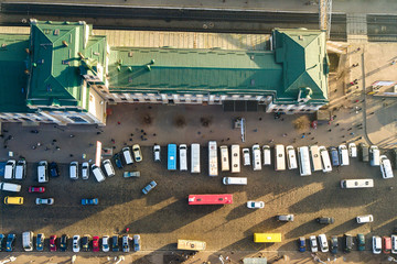 Aerial view of many cars and buses moving on a busy city street in front of railway station building in Ivano-Frankivsk city, Ukraine.