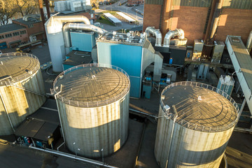 Aerial view of big fuel reservoirs in petroleum industrial zone and metal exhaust pipes of oil refinery factory.