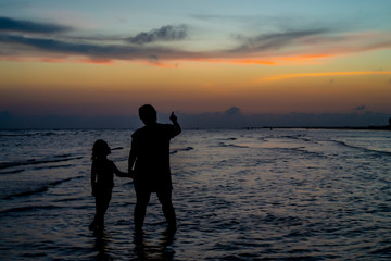 Happy family having talk on beach at sunset. Toned photo. Family traveling concept.