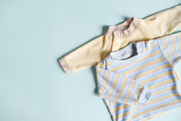 Newborn clothes concept. Shirts for baby boy on blue background.