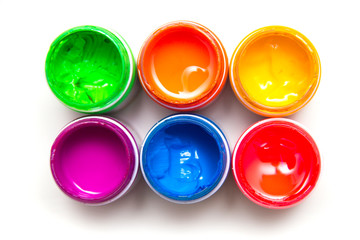 Jars with colored paint on a white background. Close-up, top view