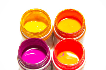 Jars with colored paint on a white background. Close-up, top view