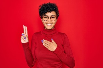 Young beautiful african american afro woman wearing turtleneck sweater and glasses smiling swearing with hand on chest and fingers up, making a loyalty promise oath