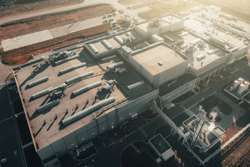 Aerial view of large industrial logistic warehouse storage or factory building at sunset, view from above.