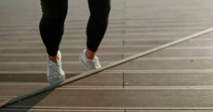 Sportswoman doing stepping exercise on pier