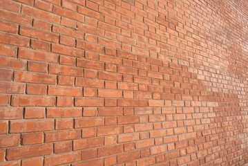 Brick wall, an angled view, lit with warm light.