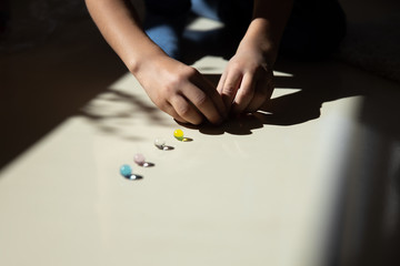Little boy placing colorful bubbles on white surface