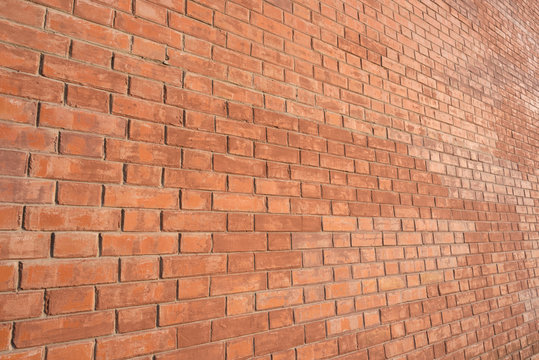 Brick wall, an angled view, lit with warm light.