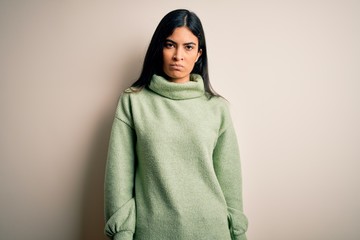 Young beautiful hispanic woman wearing green winter sweater over isolated background depressed and worry for distress, crying angry and afraid. Sad expression.
