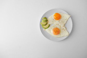Scrambled eggs with avocado and specialy on a white plate on a white background with blank copy space, top view