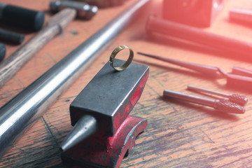 ring from gold on a goldsmith anvil in the jewelry manufactory, still life with copy space in the...
