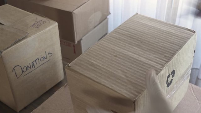 Close-up of Man preparing box of donations and writing on it