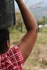 Rural woman carrying bucket with water