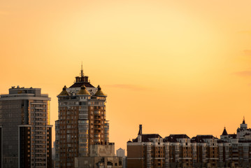 Fototapeta na wymiar Background with sunset over multi-storey buildings. Horizontal frame