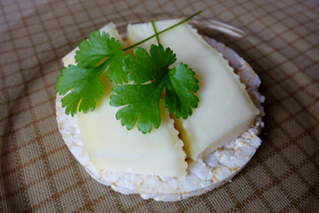 Homemade goat cheddar slices on puffed rice rounds on plate