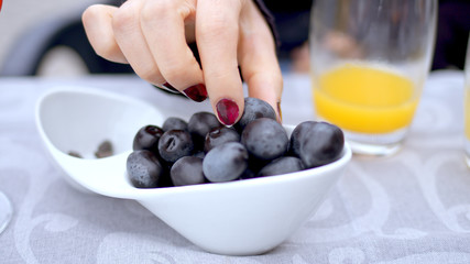 Young woman eats olives in a street restaurant - travel photography