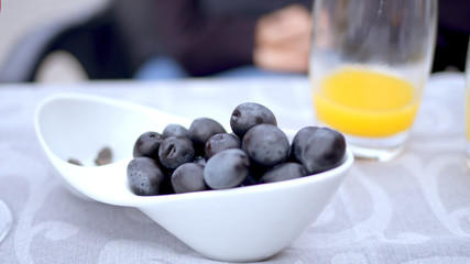 Young woman eats olives in a street restaurant - travel photography
