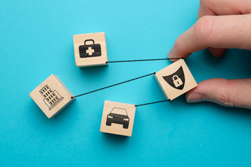 Car, health, real estate insurance concept - abstract signs on wooden cubes with a blue background.