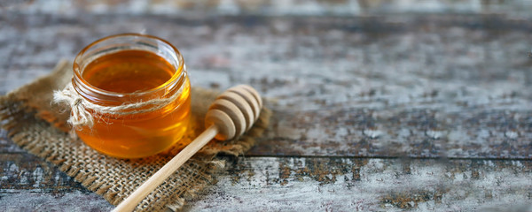 Fresh honey. Jar of flower honey. Stick for honey.