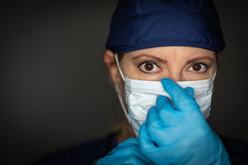 Female Doctor or Nurse Wearing Surgical Gloves Putting On Medical Face Mask