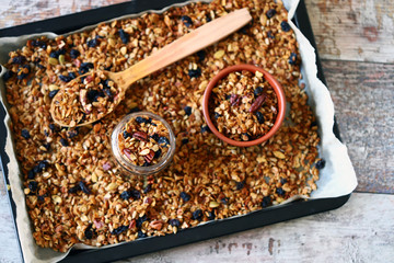 Selective focus. Homemade granola in a jar and on a baking pan. Healthy breakfast or snack. Cooking at home.