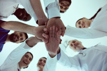 Medical workers putting their hands together and smiling