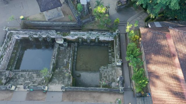 Beautiful morning at the ancient pools of Goa Gajah Elephant Cave Hindu Temple in Ubud, Bali. Aerial cinematic pan across the temple grounds of tourism hotspot Indonesia